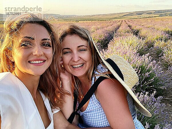 Zwei glückliche überglückliche Frauen weibliche Freunde Touristen  die selfie beim Stehen in Lavendelfeld auf Sommer sonnigen Tag  lächelnd Freundinnen machen Selbstporträt während der Ferien in der Natur