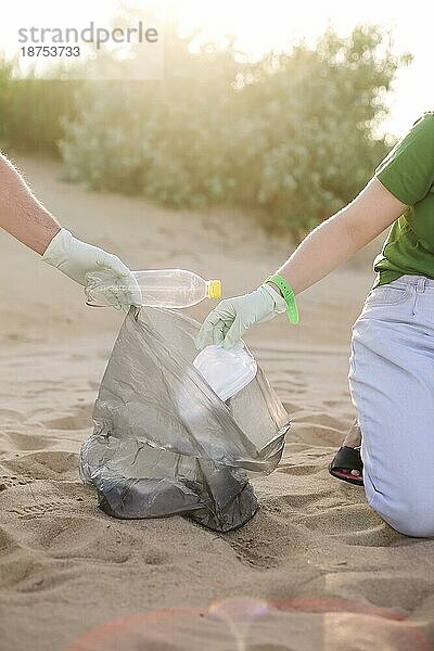 Freiwillige sammeln Müll  Plastikflaschen und Masken am Strand. Ökologie  Umwelt  Verschmutzung und ökologische Probleme Konzept