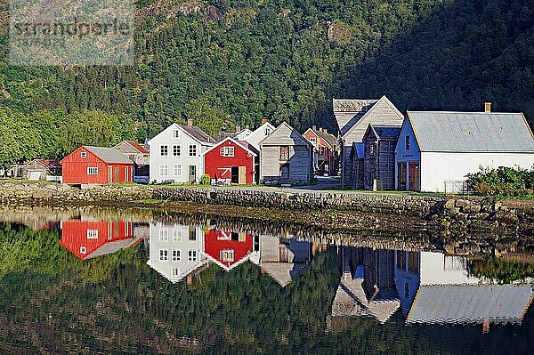 Holzhäuser spiegeln sich im ruhigen Gewässer  hohe Berge  Sognefjord  Laerdal  Norwegen  Europa