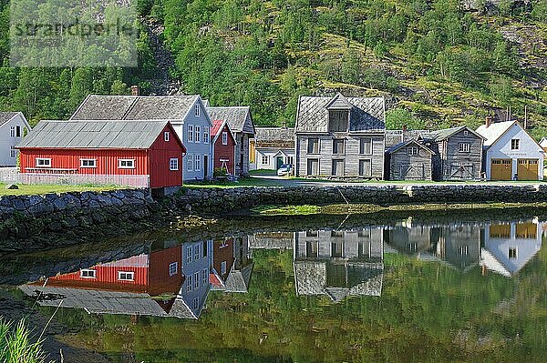 Holzhäuser spiegeln sich im ruhigen Gewässer  hohe Berge  Sognefjord  Laerdal  Norwegen  Europa