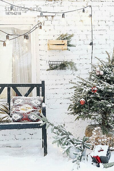 Home porche mit schneebedeckten Zweigen eines Weihnachtsbaums dekoriert. Weihnachtsdekoration  verschneite Stimmung  WinterStillleben