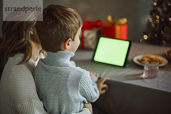 Glückliche junge Frau mit kleinem Sohn  im Gespräch mit Freunden auf virtuellem Zoom Videogespräch  feiern Neujahrsparty in Urlaub Remote Online Konferenz Chat auf Computer zu Hause