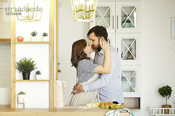 Seitenansicht eines verliebten Paares  das sich beim gemeinsamen Kochen in der Küche umarmt
