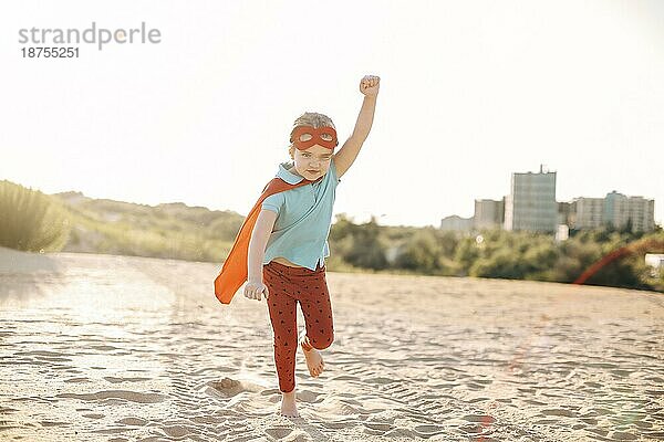 Porträt von Superhero Kind gegen blaün Himmel Hintergrund. Freude und Kindheit Konzept