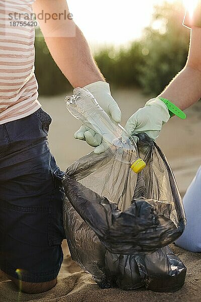 Freiwillige sammeln Müll  Plastikflaschen und Masken am Strand. Ökologie  Umwelt  Verschmutzung und ökologische Probleme Konzept
