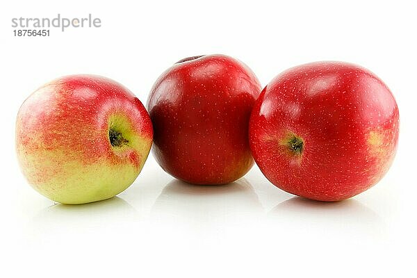Drei reife rote Äpfel in Reihe vor weißem Hintergrund
