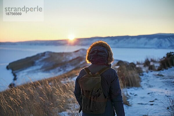Junger Mann steht im Winter gefrorenen Natur und beobachten ruhigen Winter nebligen Sonnenuntergang. Thinking Konzept  volle Freiheit Foto  schöne Landschaft. Ogoy Insel  Baikalsee  Sibirien  Russland  Europa