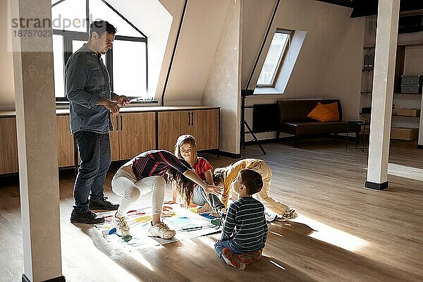 Glückliche große Familie  die Spaß zusammen  Kinder mit Vater spielen Twister Spiel zu Hause. Familie Aktivität