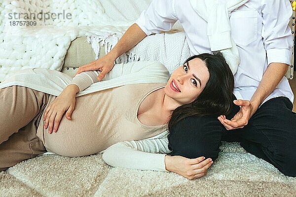 Junge Familie Paar wartet auf Baby. Blick von oben auf liebevolle Mann umarmt schwangere Frau beim Entspannen zusammen zu Hause  Mann und Frau zukünftige Eltern erwarten Kind. Schwangerschaft und Elternschaft