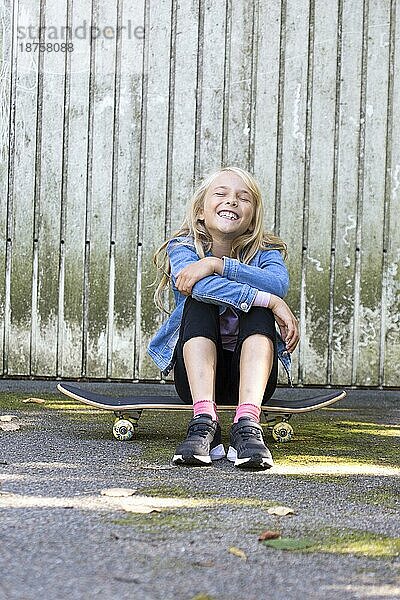 Mädchen (10) sitz auf Skateboard  Kiel  Schleswig-Holstein  Deutschland  Europa