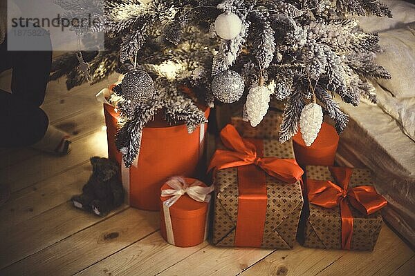 Hell beleuchtete Weihnachtsbaum mit vielen Geschenken auf dem Holzboden in der Nähe von Fenster mit Kopie Raum. Weihnachten und Frohes Neues Jahr Konzept