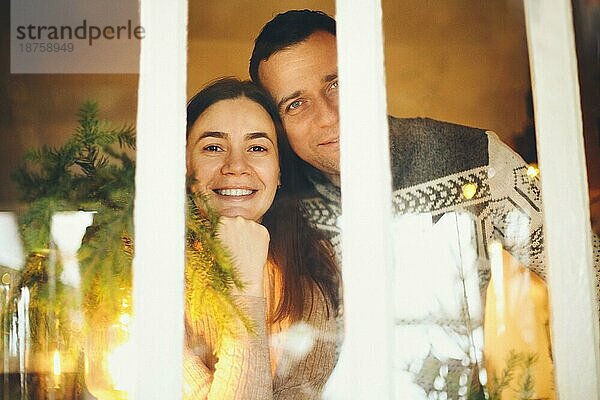 Porträt der glücklichen Familie Paar Mann und Frau lächelnd in die Kamera  während die Winterferien zusammen in gemütlichen warmen festlichen häuslichen Atmosphäre. Menschen in Erwartung des neuen Jahres und Weihnachten