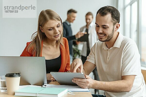 Junge Geschäftsleute arbeiten am Laptop