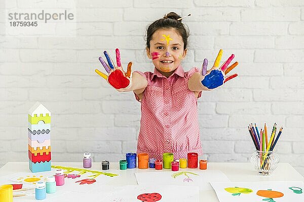 Lächelnd Porträt Mädchen zeigt ihre gemalten bunten Hand Kamera