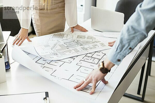 Architekten-Ingenieur bespricht Tisch mit Blaupause. Schönes Foto