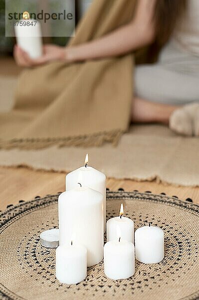 Frau meditiert mit Tablett mit Kerzen