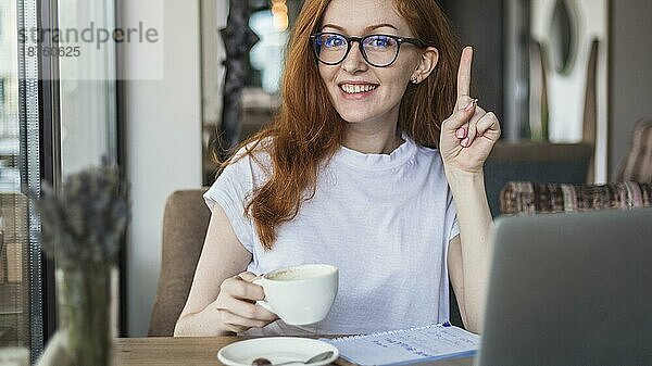 Frau mit Kaffeetasse und Fingerzeig