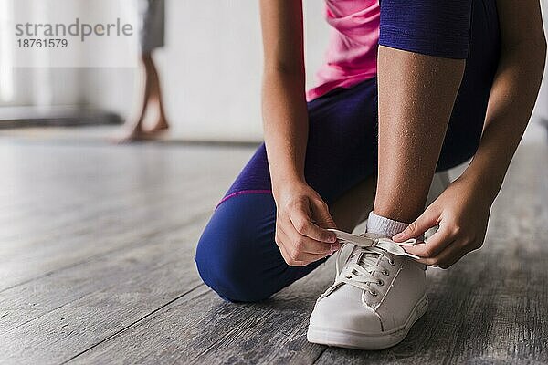 Niedrigen Abschnitt Mädchen binden Schnürsenkel weiße Schuhe. Auflösung und hohe Qualität schönes Foto