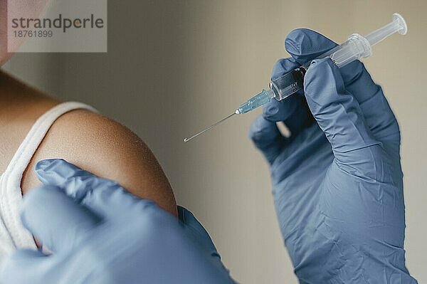 Arzt mit Handschuhen bei der Verabreichung des Impfstoffs für kleine Kinder