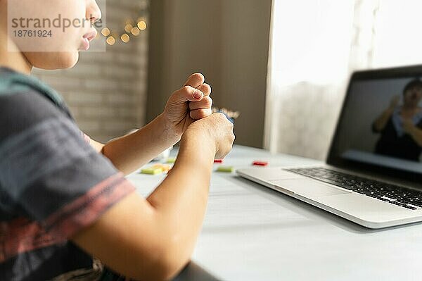 Junge spricht mit seinem Lehrer online Schule