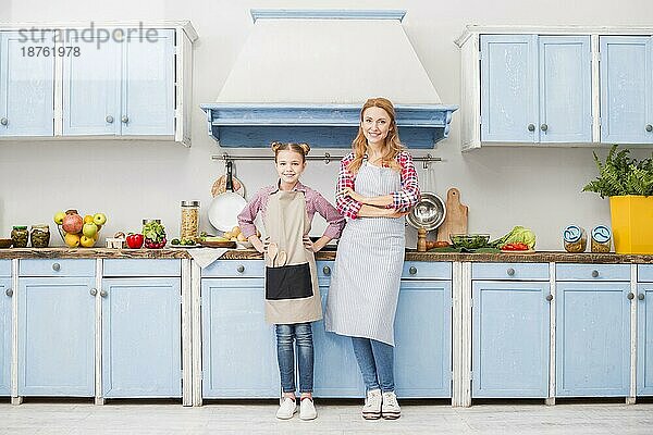 Portrait glückliche Mutter Tochter Schürze stehend Küche