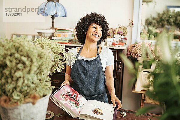 Glückliche junge Blumenhändlerin mit Blumenalbum-Shop