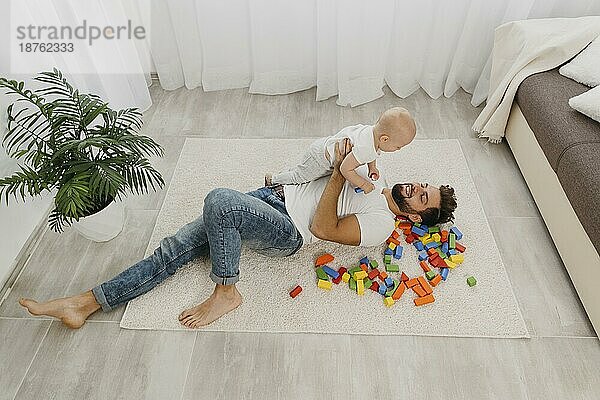 Hohe Winkel Vater spielt Boden zu Hause mit Baby