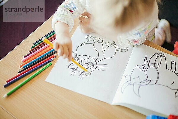 Mädchen hält Bleistift am Tisch. Foto mit hoher Auflösung