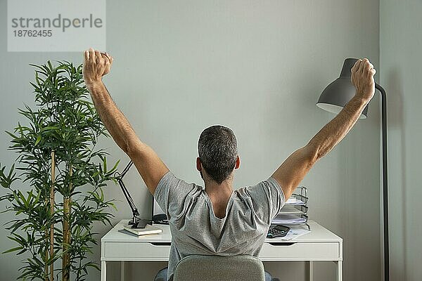 Rückenansicht Mann streckt seine Arme bei der Arbeit von zu Hause aus. Auflösung und hohe Qualität schönes Foto