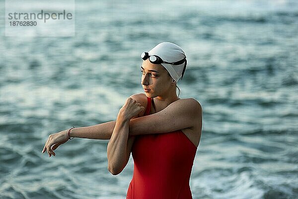 Vorderansicht Schwimmerin  die sich vor dem Schwimmen dehnt. Foto mit hoher Auflösung