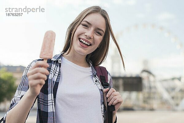 Porträt junge glückliche Frau hält Eis am Stiel Vergnügungspark
