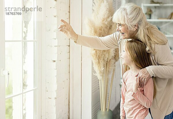 Oma mit Mädchen nach Hause schauen Fenster