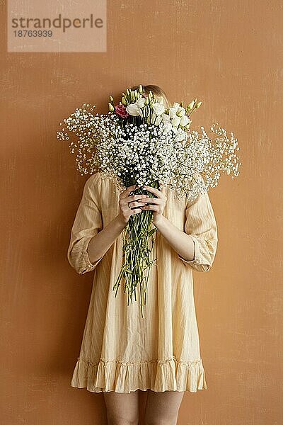 Frontansicht Frau hält Blumenstrauß prächtige Frühlingsblumen. Foto mit hoher Auflösung