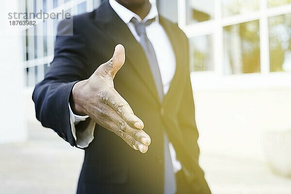 Eleganter Geschäftsmann streckt die Hand aus