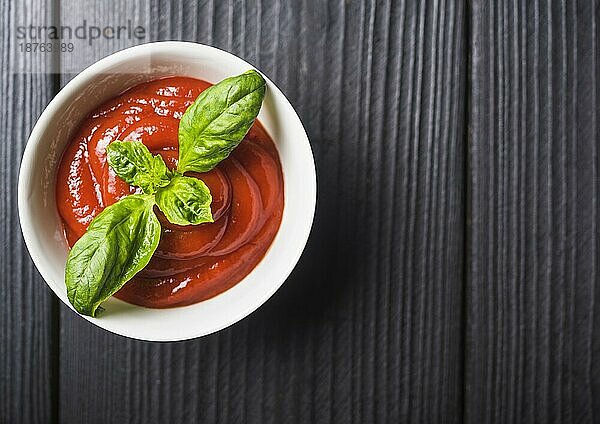 Draufsicht Tomatensauce mit grünen Basilikumblättern Holzkulisse. Auflösung und hohe Qualität schönes Foto