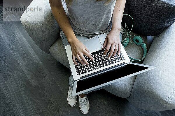 Junge Frau tippt auf Laptop