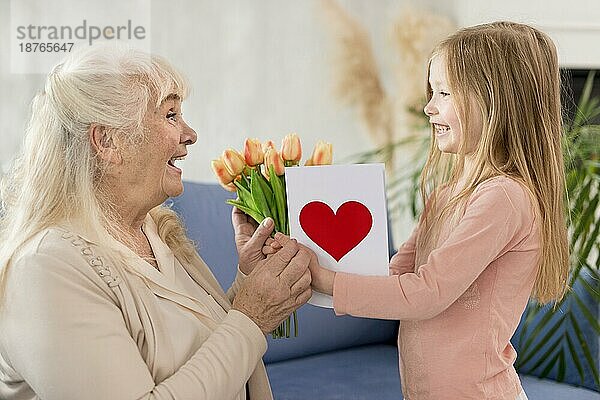 Oma mit Blumen von kleinem Mädchen