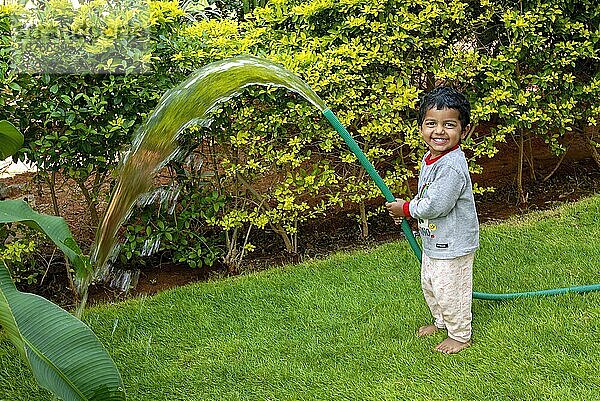 Ein südindisches 2 Jahre altes Kleinkind Junge Ashwin Bewässerung Rasen  Karnataka  Südindien  Indien  Asien
