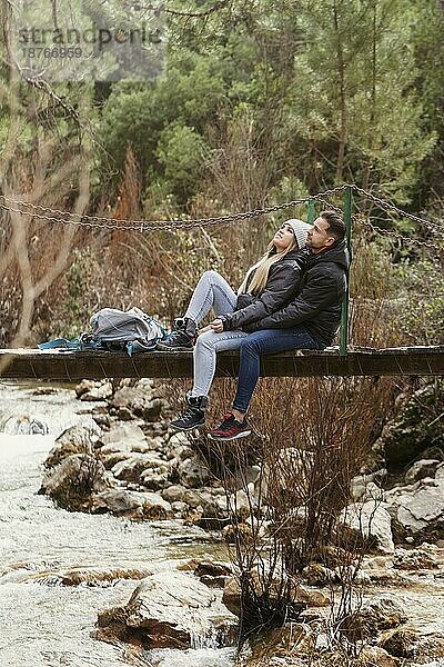 Ehepaar mit Rucksack sitzende Brücke