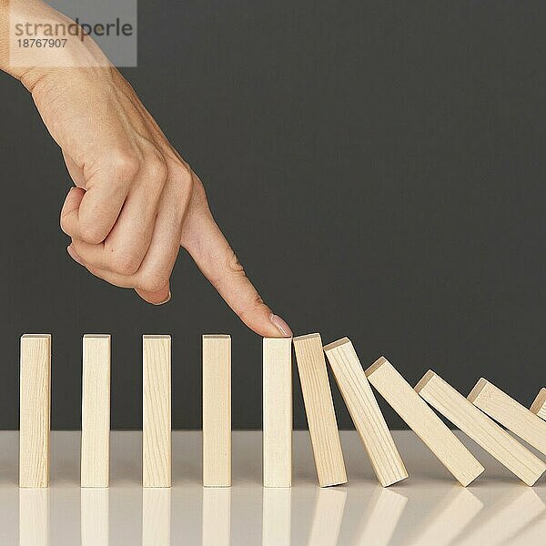 Dominospiel mit Holzsteinen  die die finanziellen Probleme darstellen