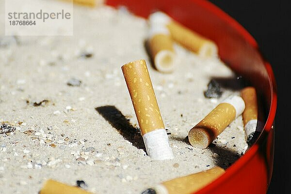 Aschenbecher mit Zigarettenkippen  Gefahr für die Sucht