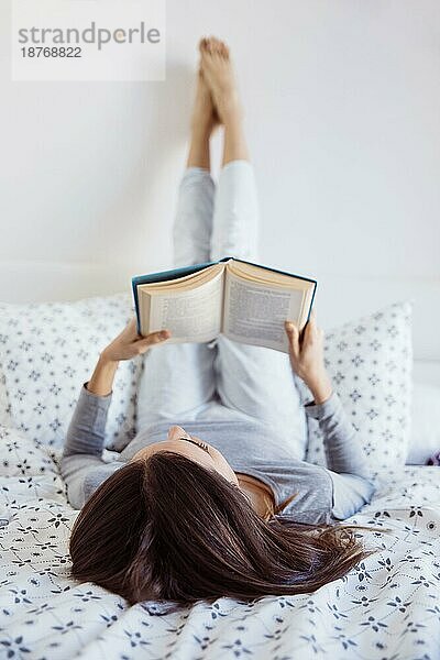 Junge Frau liest im Bett