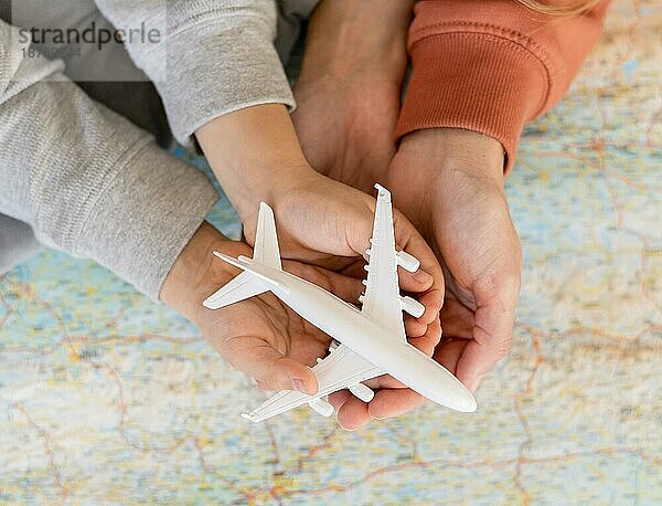 Mutter Kind zu Hause hält Flugzeug Figur oben Karte. Schönes Foto