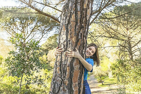 Junge Frau umarmt Baum Wald