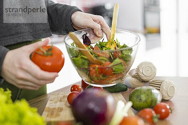 Hand hält Schüssel Salat. Foto mit hoher Auflösung