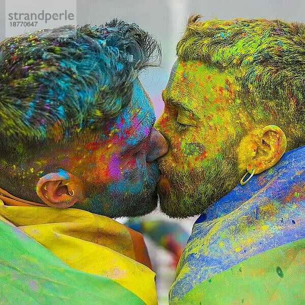 Junge Schwule küssen holi Farbe Festival