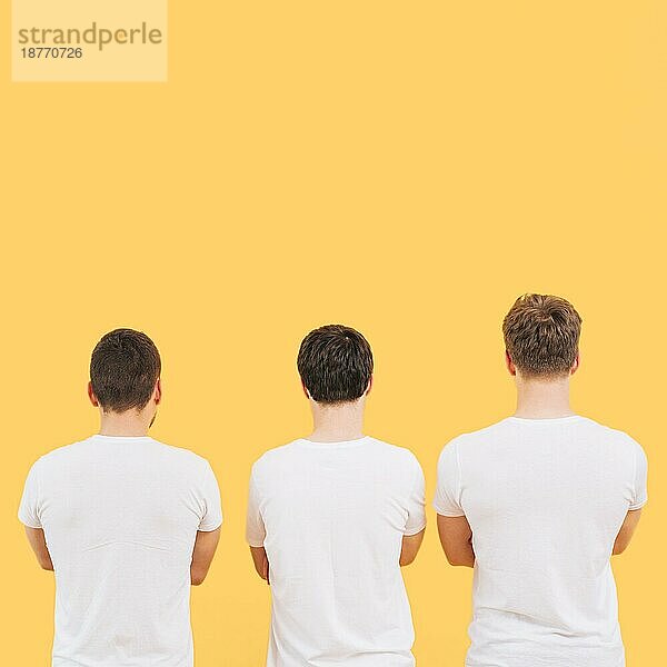 Rückansicht Männer weißes T-Shirt gegen gelben Hintergrund stehen. Hohe Auflösung Foto
