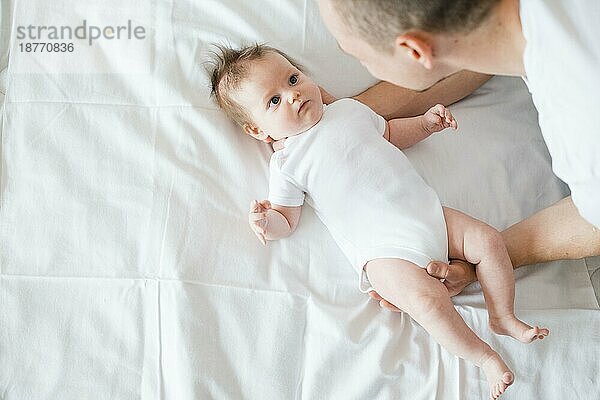 Vater umarmt sanft das Babybett. Foto mit hoher Auflösung