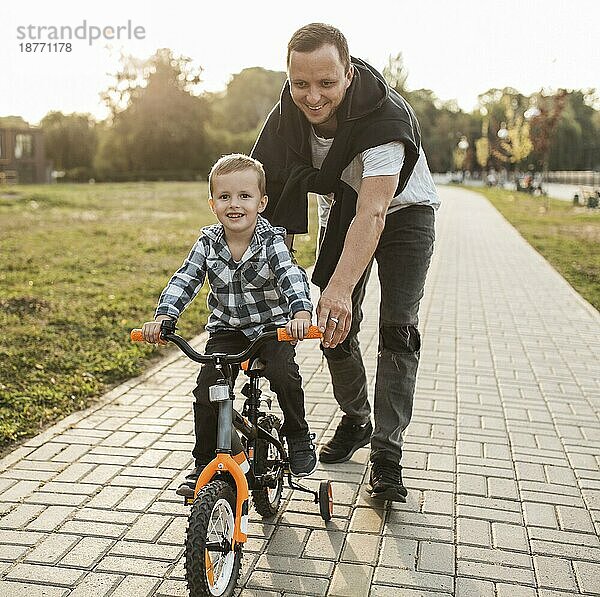 Vater hilft seinem Sohn beim Fahrradfahren