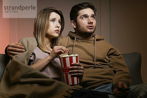 Paar sieht fern und ißt Popcorn